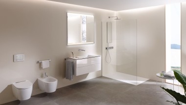 O privire în interiorul unei băi mari cu toaletă de duș Geberit AquaClean Mera, mobilier de baie și ceramică de baie (© Geberit)