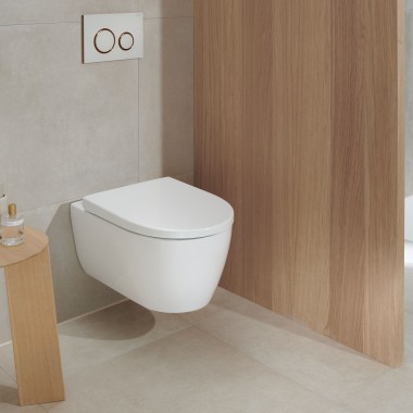 Un WC alb din ceramică într-o baie cu elemente din lemn arată modern chiar și după mulți ani (aici: WC Geberit iCon și clapetă de acționare Geberit Sigma20) Un WC alb din ceramică într-o baie cu elemente din lemn arată modern chiar și după mulți ani (aici: WC Geberit iCon și clapetă de acționare Geberit Sigma20)