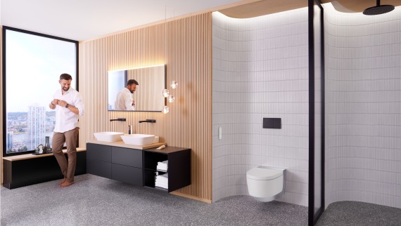 Bărbat în baia Geberit ONE dotată cu vas WC cu funcţie de bideu Geberit AquaClean Mera şi cu oglindă Geberit Option Plus Bărbat în baia Geberit ONE dotată cu vas WC cu funcţie de bideu Geberit AquaClean Mera şi cu oglindă Geberit Option Plus