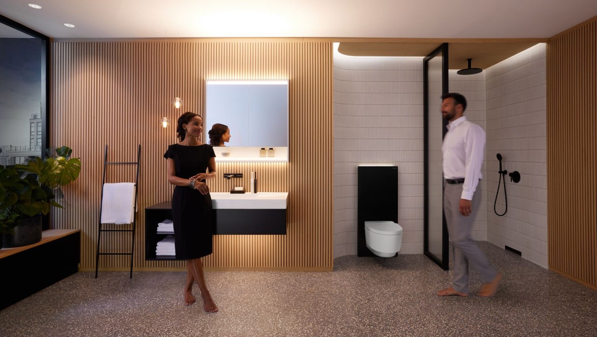 Domnul şi doamna într-o baie perfect luminată cu produsele Geberit ONE Domnul şi doamna într-o baie perfect luminată cu produsele Geberit ONE