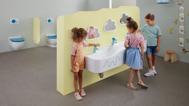 Copii jucându-se într-un spaţiu sanitar cu produse Geberit Bambini