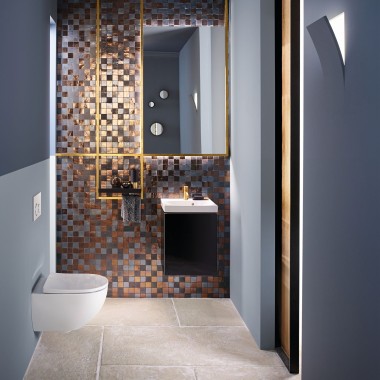 Vedere într-o baie modernă pentru oaspeți, cu un WC Acanto și o lavoar Acanto în fața unui panou de mozaic din spate Vedere într-o baie modernă pentru oaspeți, cu un WC Acanto și o lavoar Acanto în fața unui panou de mozaic din spate