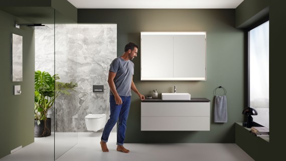 Un bărbat stă într-o baie cu mobilier de înaltă calitate din seria Geberit ONE Un bărbat stă într-o baie cu mobilier de înaltă calitate din seria Geberit ONE