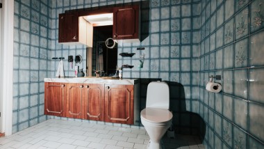 Baie cu gresie albastră și WC pe podea Baie cu gresie albastră și WC pe podea