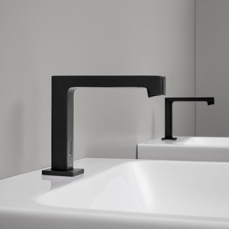 Baterie electronică cu montaj pe stativ Geberit Brenta în negru mat, într-o zonă de WC publică Baterie electronică cu montaj pe stativ Geberit Brenta în negru mat, într-o zonă de WC publică