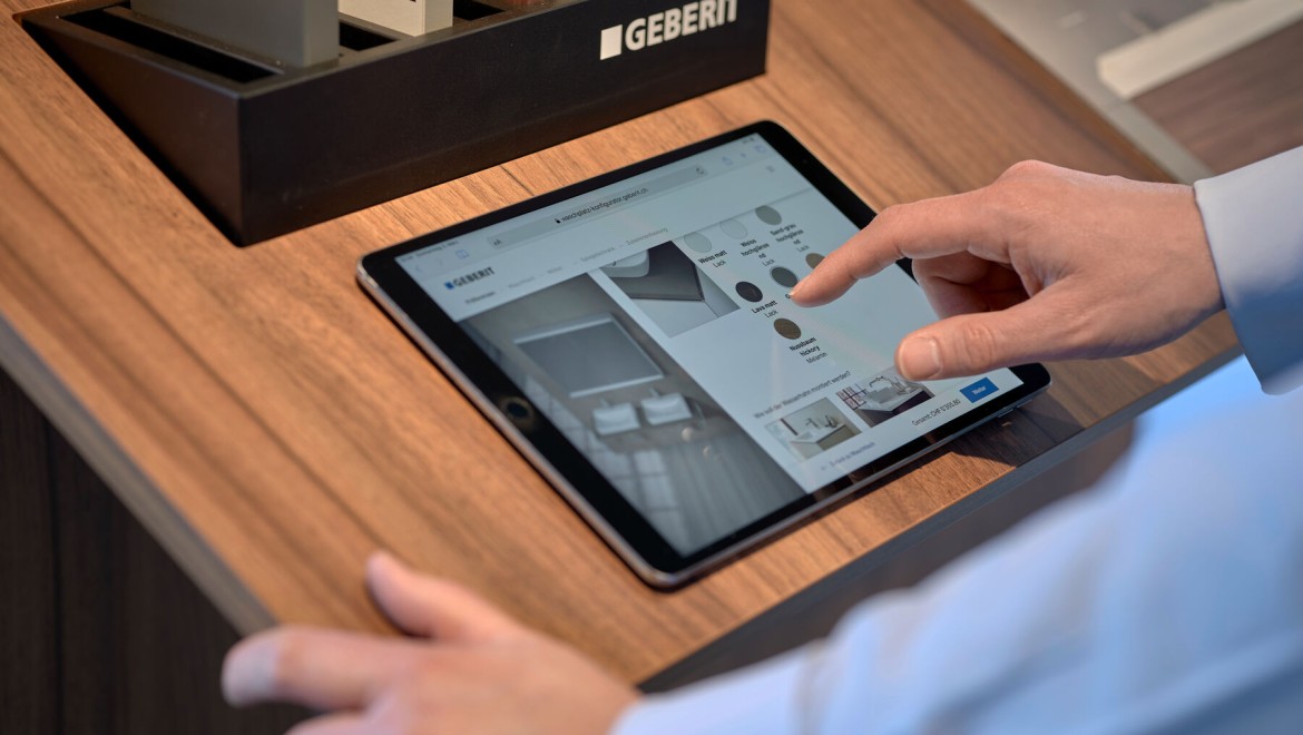 Un bărbat cu o tabletă selectează produse într-un configurator Un bărbat cu o tabletă selectează produse într-un configurator