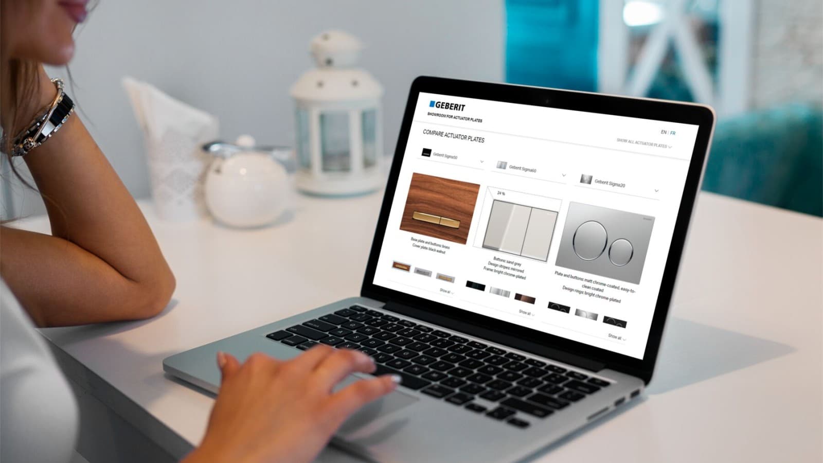 O doamnă deschide showroom-ul de clapete de acţionare Geberit de pe laptop O doamnă deschide showroom-ul de clapete de acţionare Geberit de pe laptop