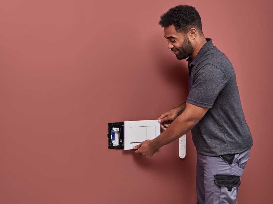 Bărbat instalând unitatea de extracție a mirosurilor Geberit DuoFresh Bărbat instalând unitatea de extracție a mirosurilor Geberit DuoFresh