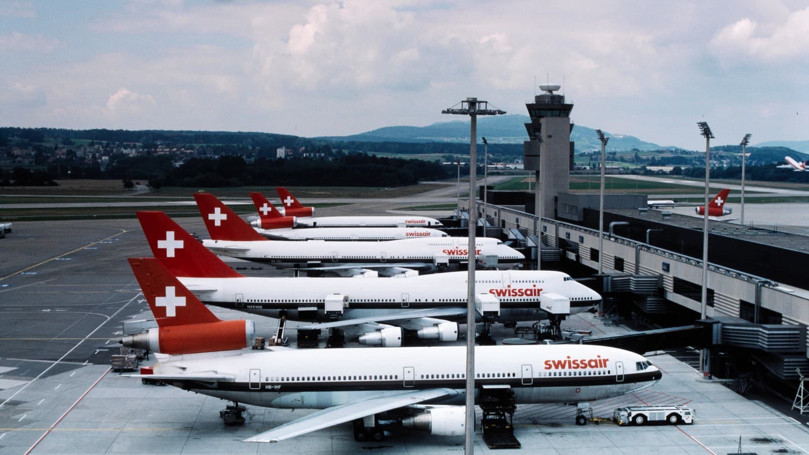 Aeronave ale fostei companii Swissair sunt parcate la platforma Terminalului A din Zurich în anii 1980 (© ETH-Bibliothek Zürich) Aeronave ale fostei companii Swissair sunt parcate la platforma Terminalului A din Zurich în anii 1980 (© ETH-Bibliothek Zürich)